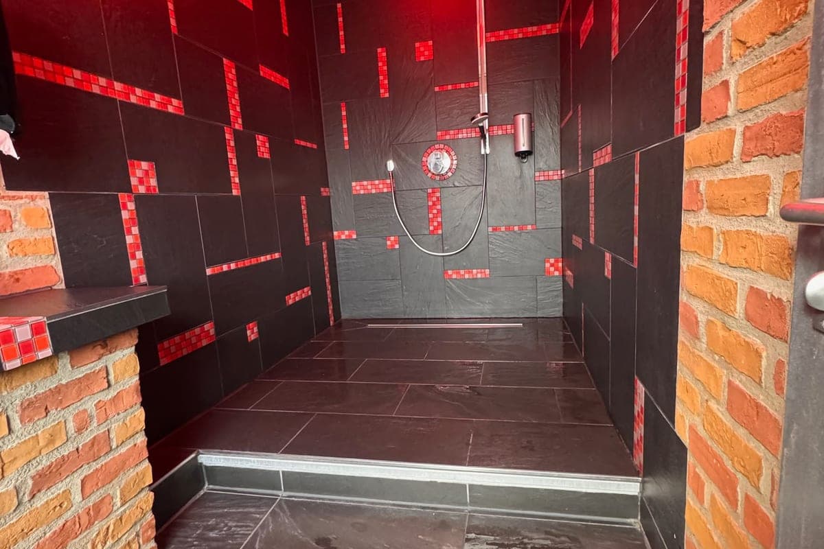 Begehbare Dusche mit Schiefer, Mosaik und Backsteinwand