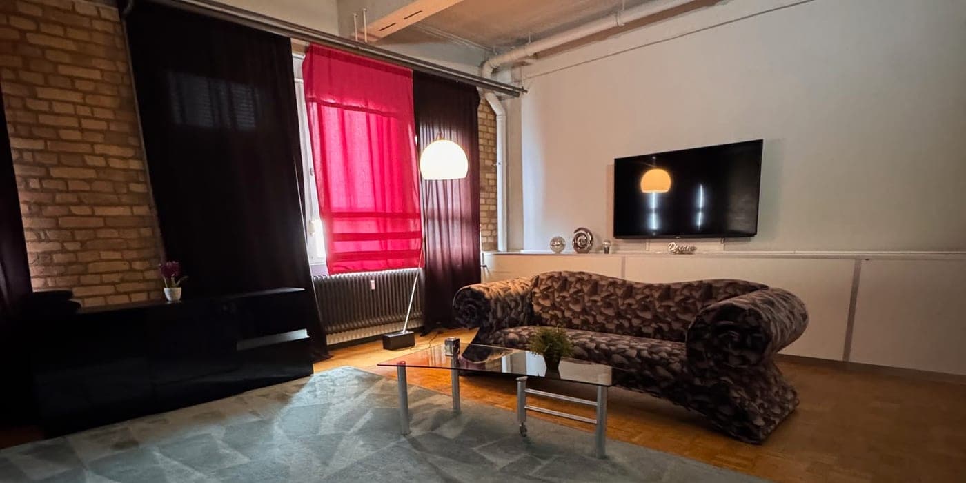 Loft-Lounge mit Backsteinwand und Designer-Sofa bei Meine Perlen in Offenbach