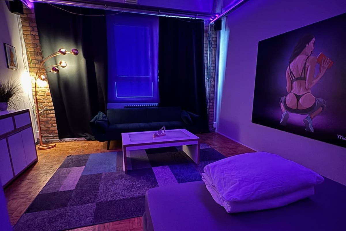 Zimmer mit Stehlampe, Sofa und Backstein in lila Licht